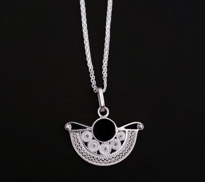 Dije precolombino con panderos y zigzag en plata. 